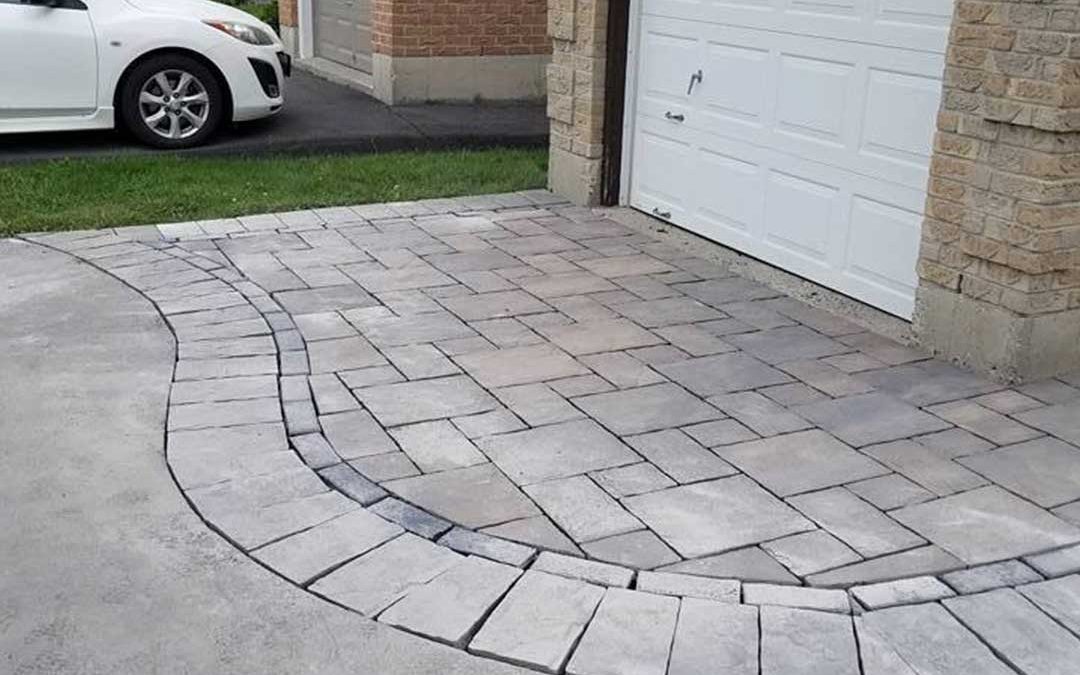 interlocking stone patio at top of driveway in front of garage