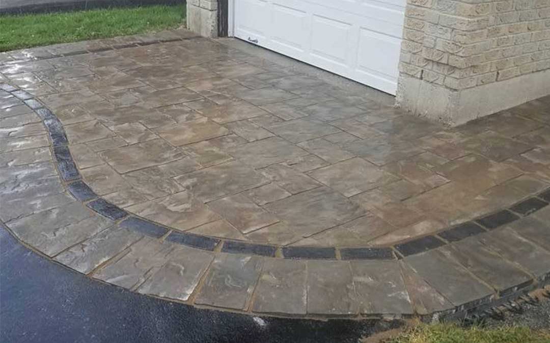 interlocking stone patio at top of driveway in front of garage